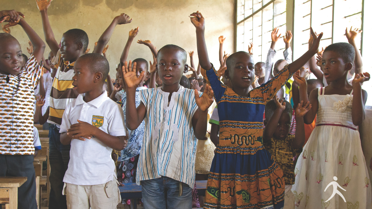 Children enthusiastically participating in Walk Thru the Bible hand signs and learning God's Word