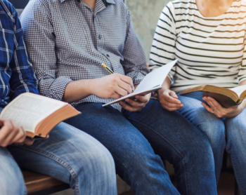 group of people's legs with bibles in their hands