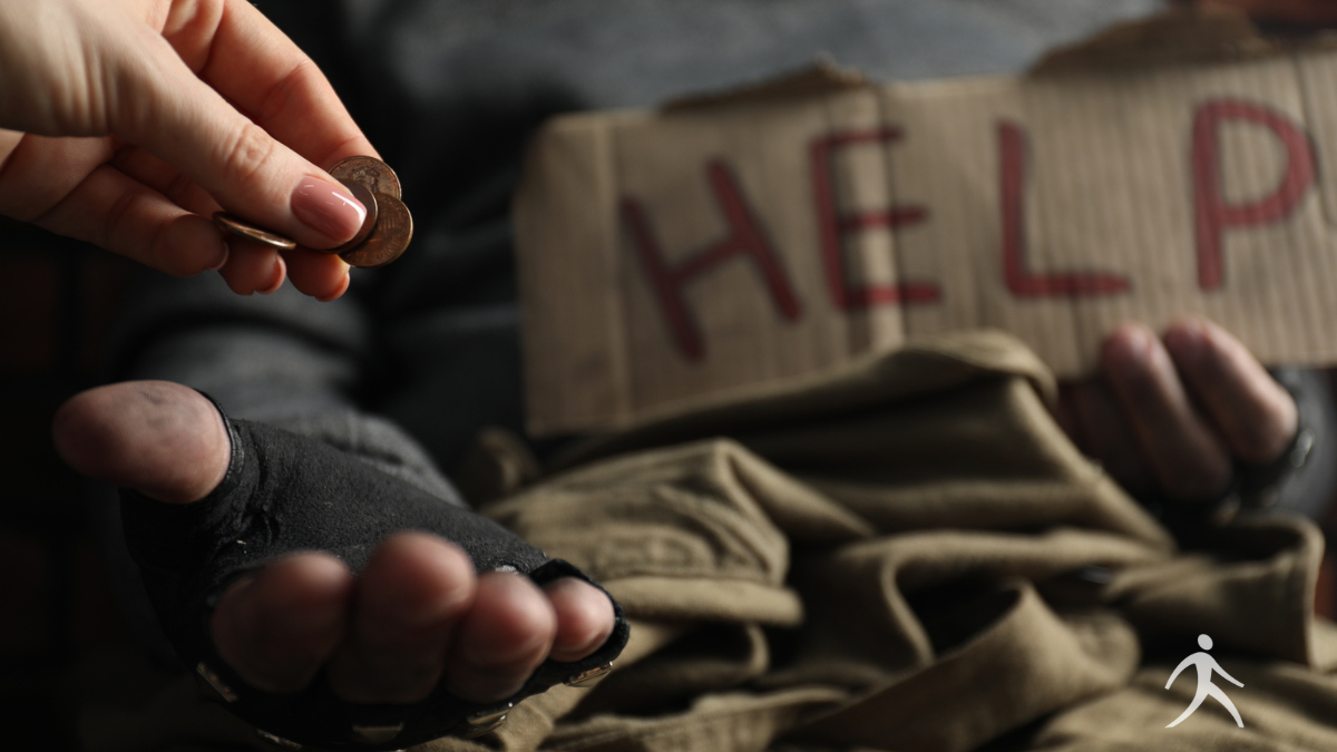 A hand placing coins into an offering box