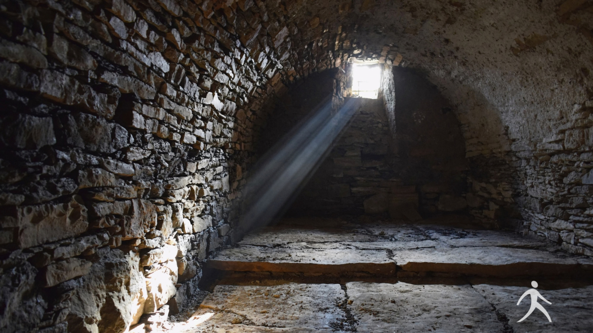 Light entering a dark stone room representing God's presence with Joseph